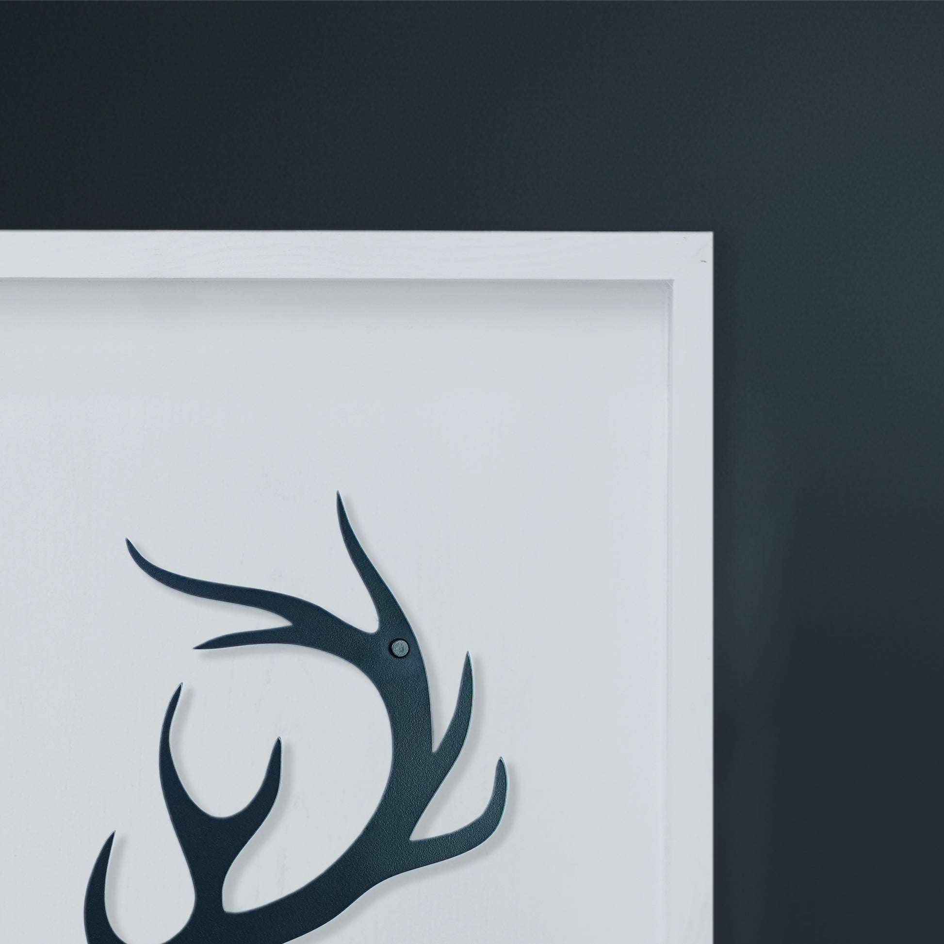 Black deer head silhouette on a white background with a dark gray border