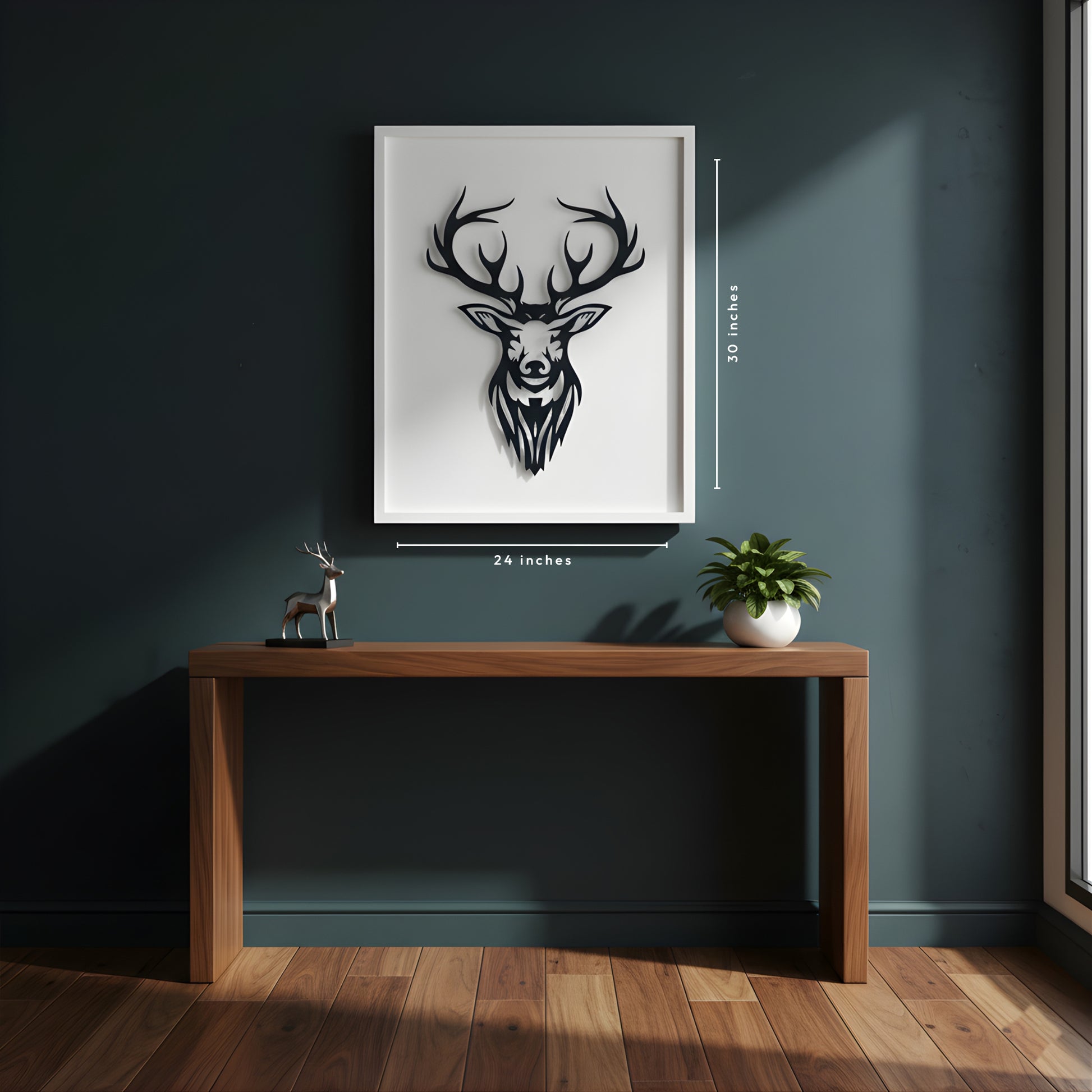 Framed artwork of a deer head on a wall above a wooden desk with a plant and small deer statue.