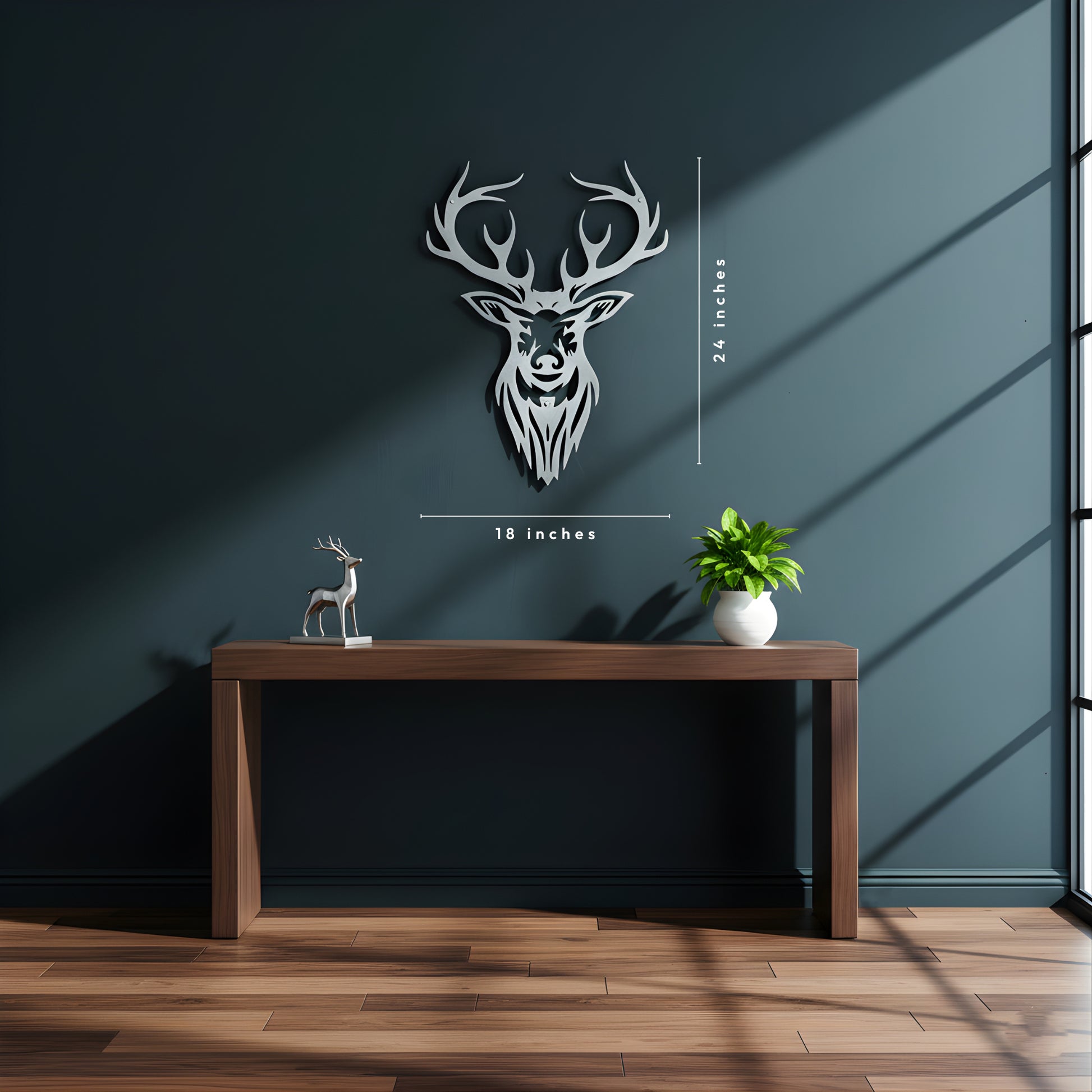 Decorative wall art of a deer head on a dark wall with a wooden table and plant.