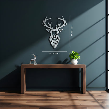 Decorative wall art of a deer head on a dark wall with a wooden table and plant.