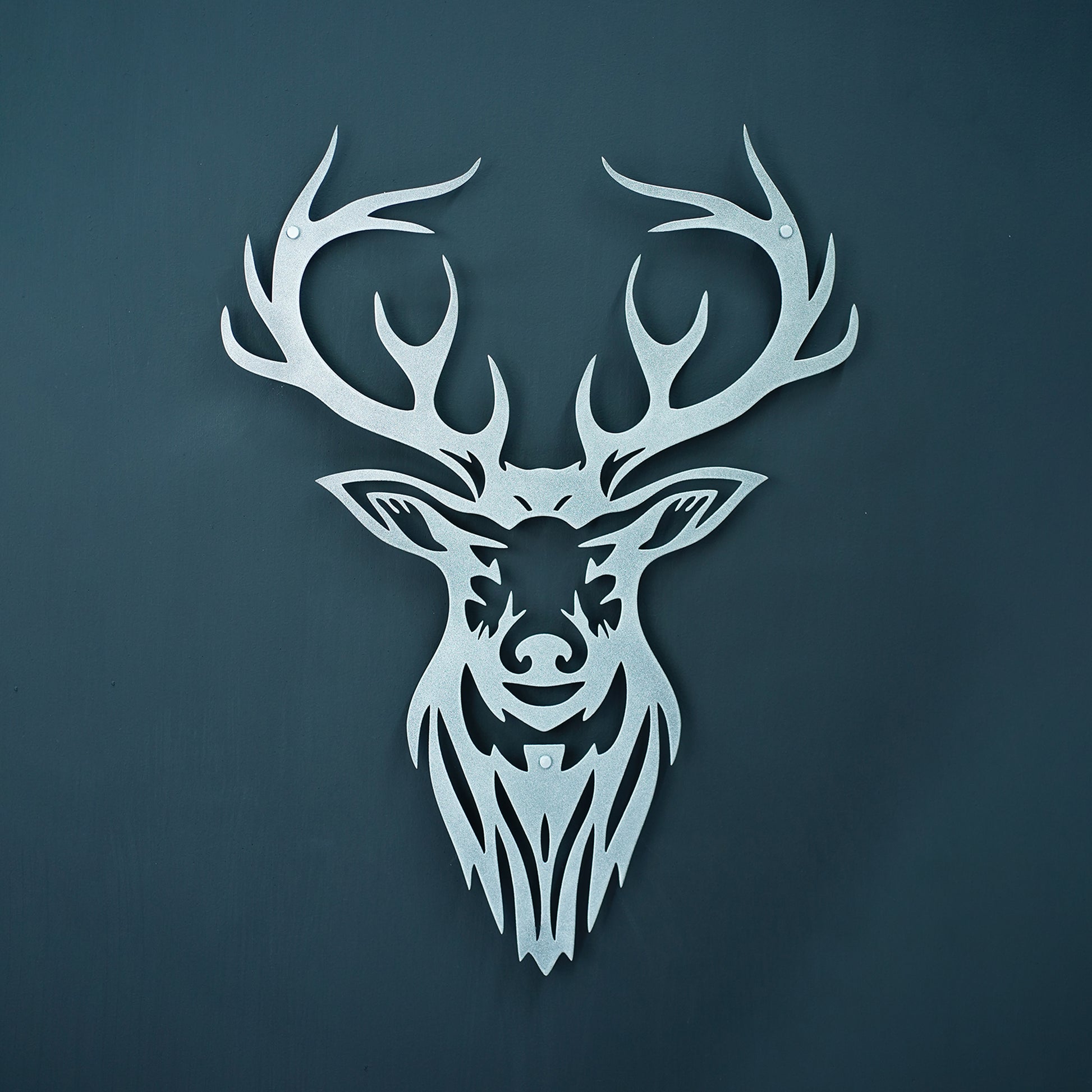 Decorative metal deer head with large antlers on a dark blue background