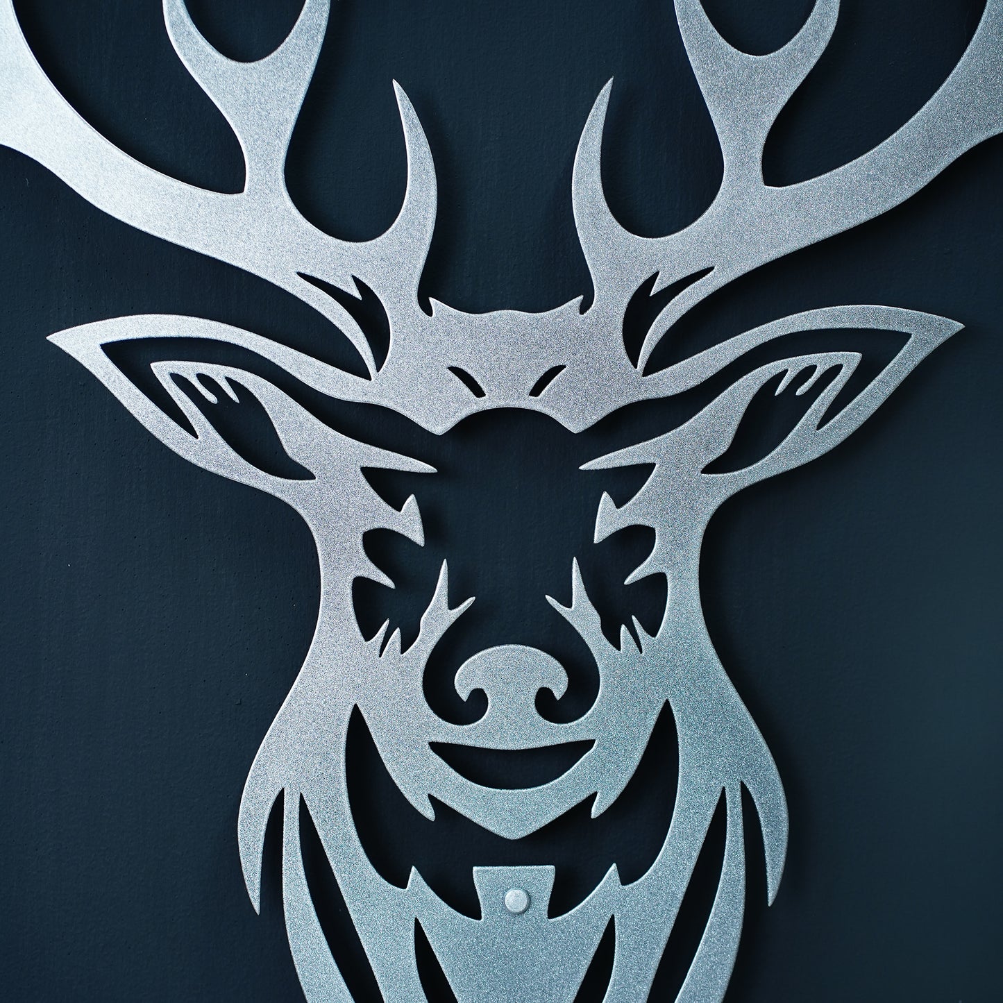 Metallic deer head cutout on a dark background