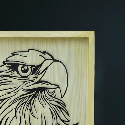Wooden frame and metal wall art with an engraved eagle design on a dark background