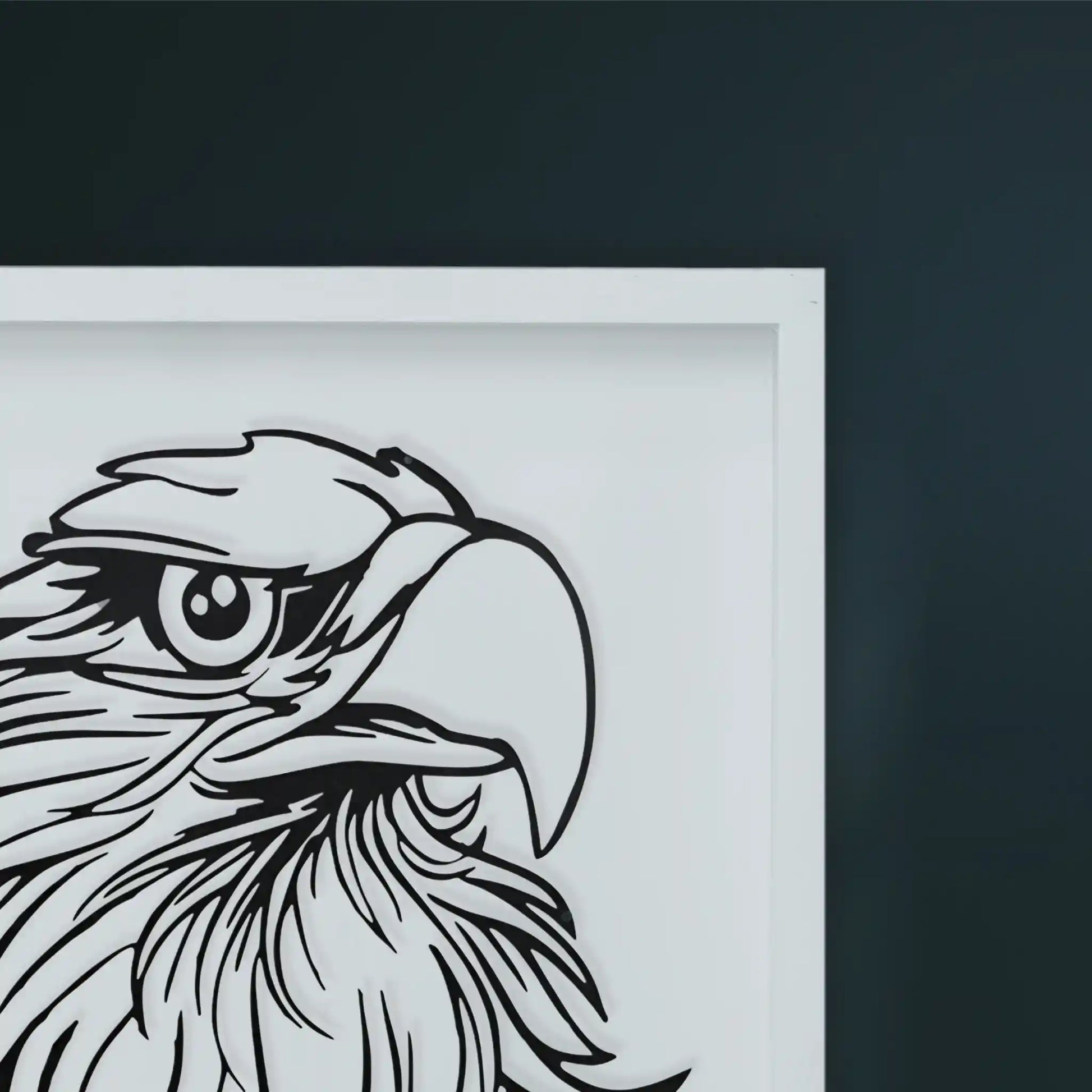 Black metal wall art in white Framed artwork of an eagle's head on a dark wall