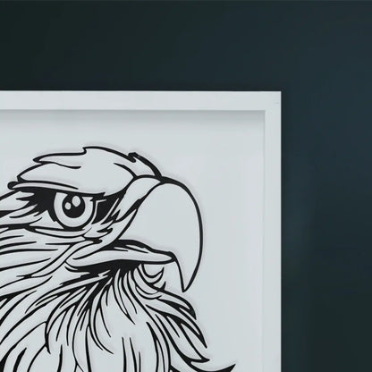 Black metal wall art in white Framed artwork of an eagle's head on a dark wall