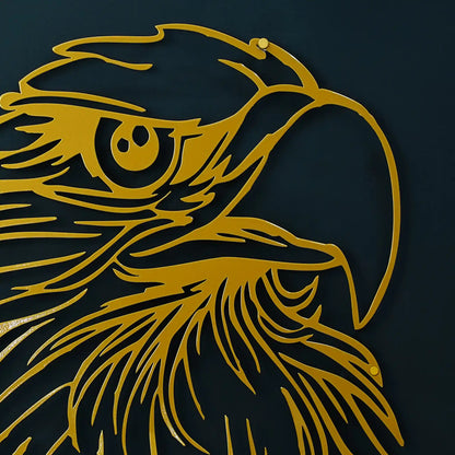 Gold metal wall art depicting a stylized eagle head profile, mounted on a dark navy blue wall.
