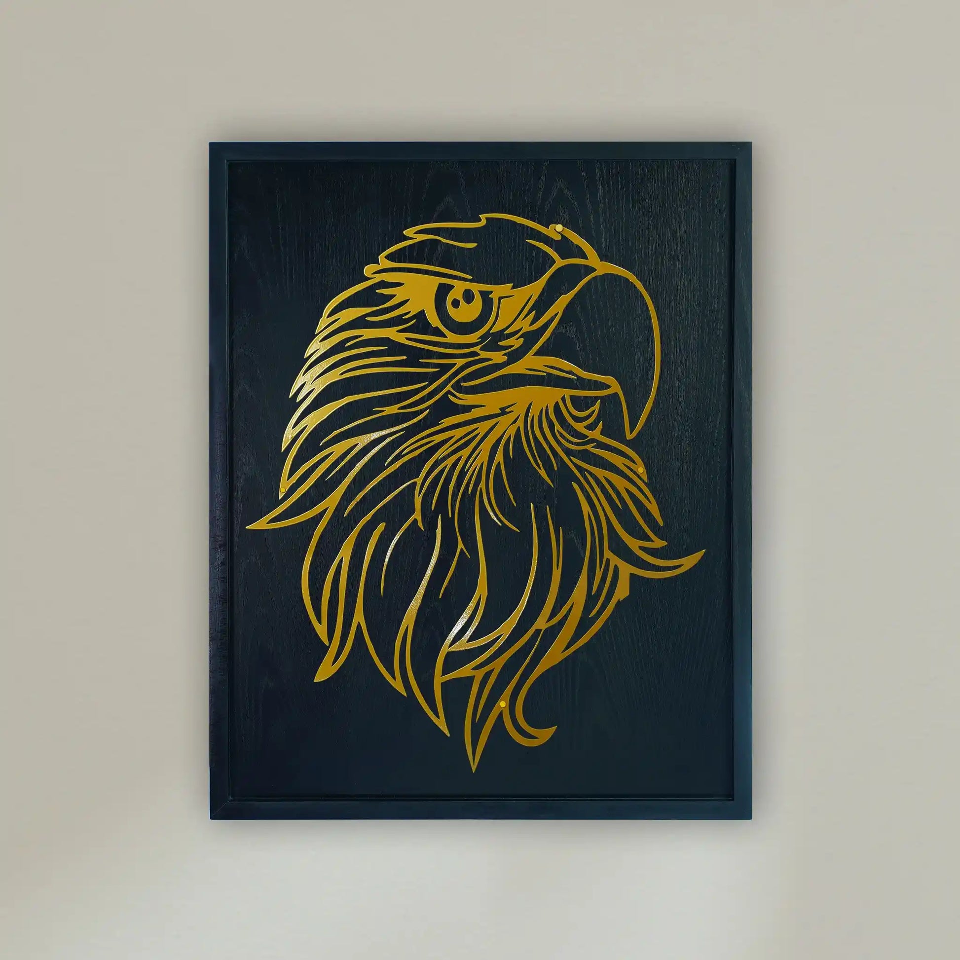 wooden Framed metal wall art featuring a stylized golden eagle head on a black wooden frame, hung on a light beige wall.