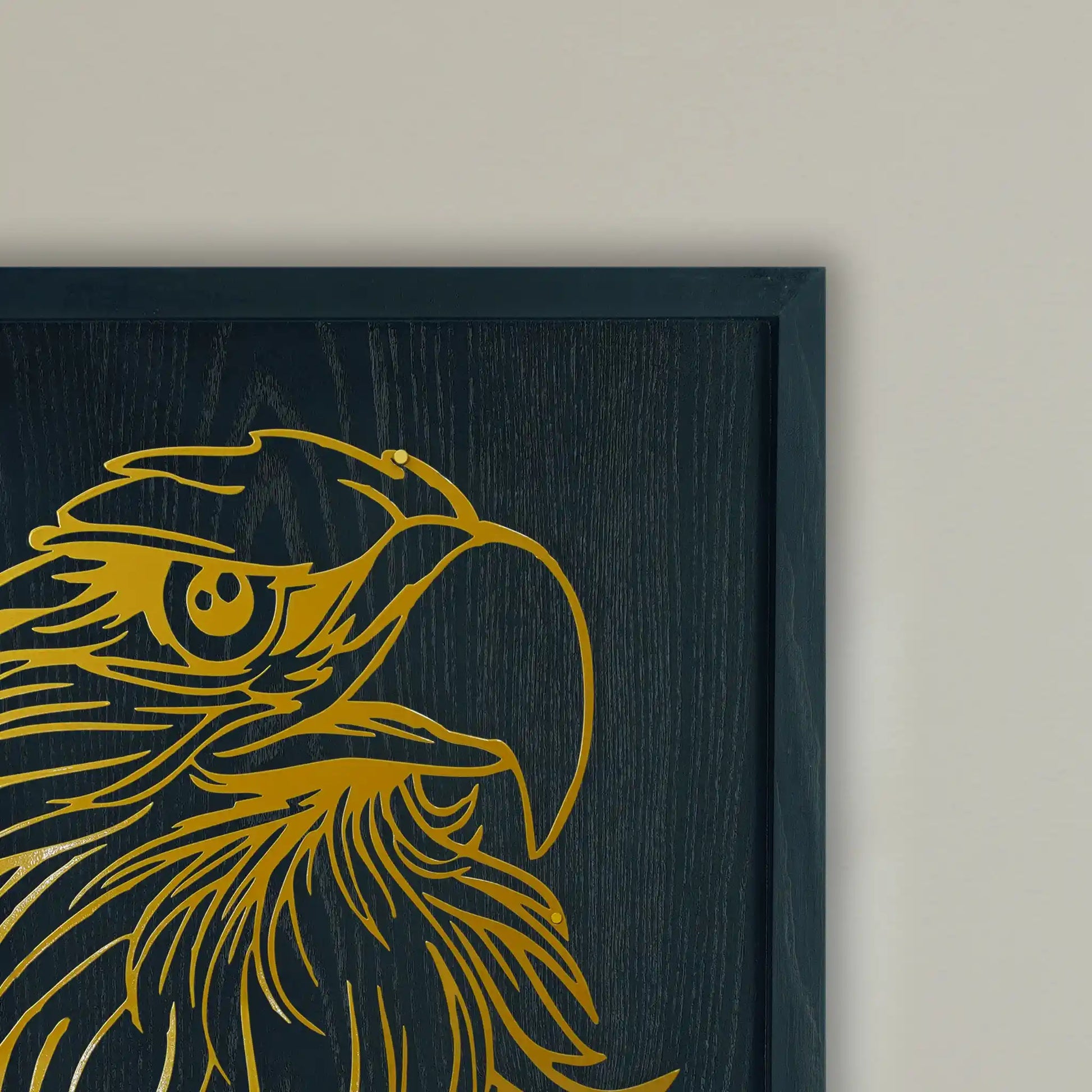 Close-up of Black wooden Framed with Golden metal wall art eagle on a Beige background wall