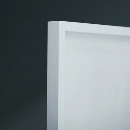 Close-up of a white wooden frame corner against a dark gray background.