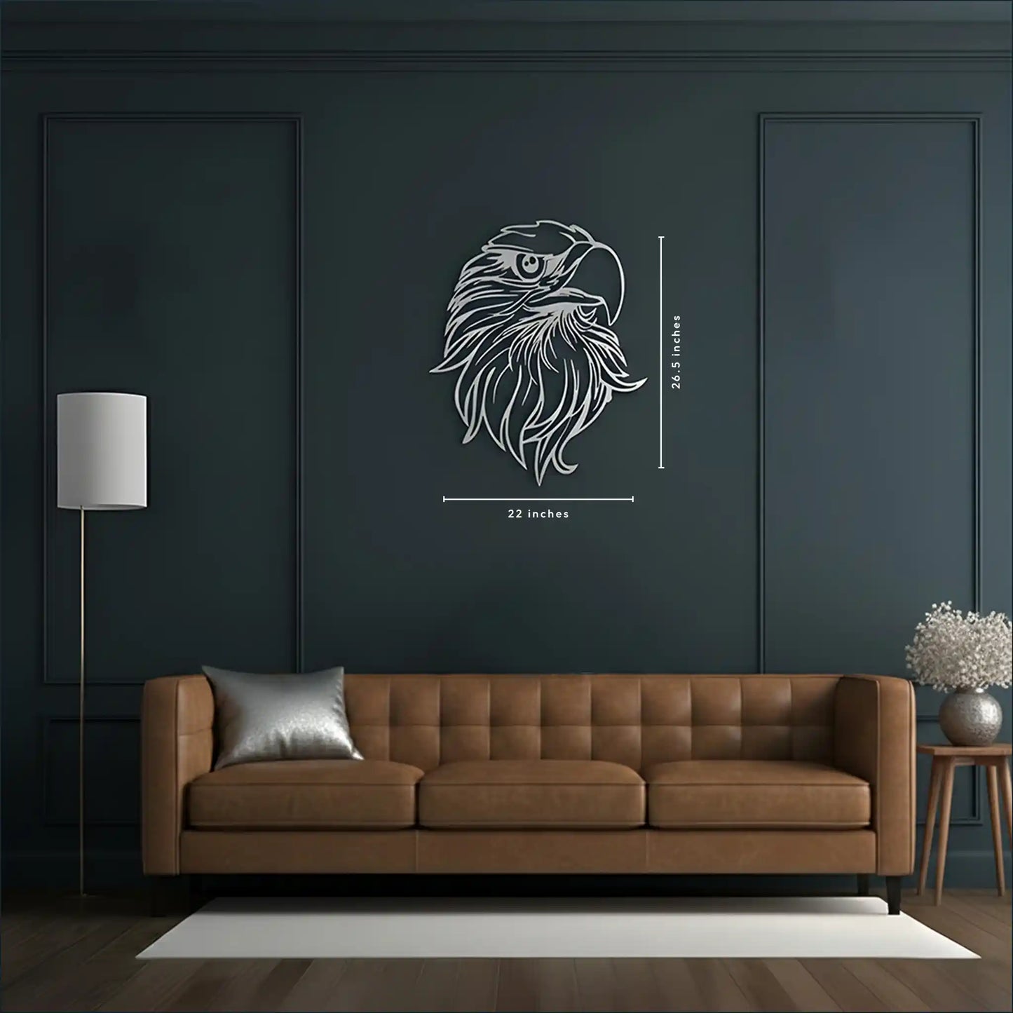 A brown tufted leather sofa in a modern living room, with a dark charcoal wall behind it featuring a metal wall art silver eagle head wall decal with dimension markings (22 inches wide by 26.5 inches tall).