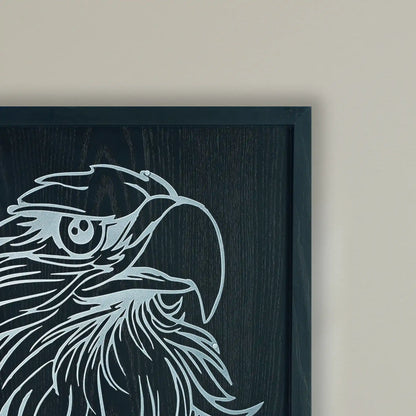 close-up of framed artwork of an eagle's head in metal on a black wooden frame on a beige color wall in background