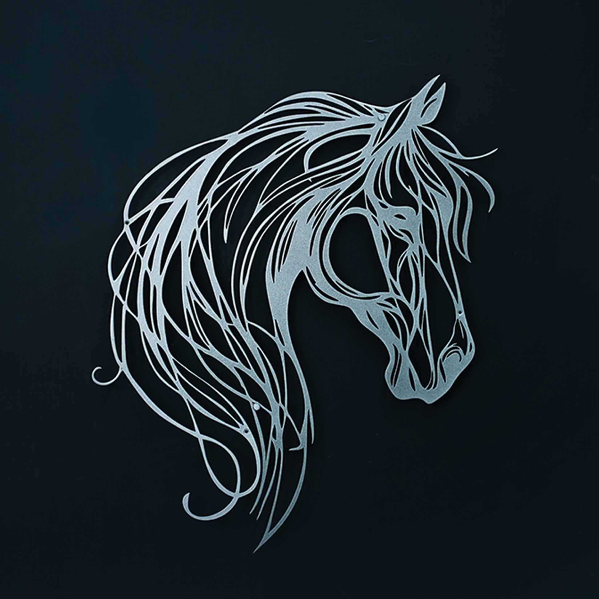 Decorative metal horse head sculpture on a black background