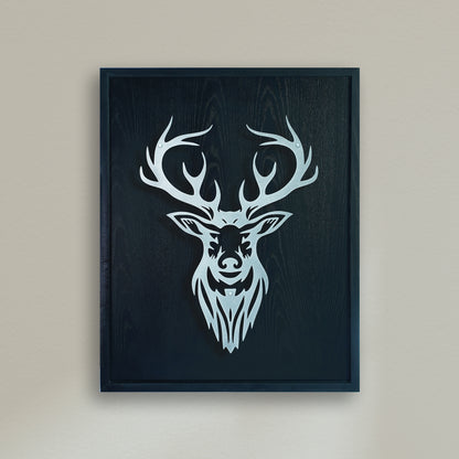 Black wooden Framed artwork of a deer head with antlers on a beige wall