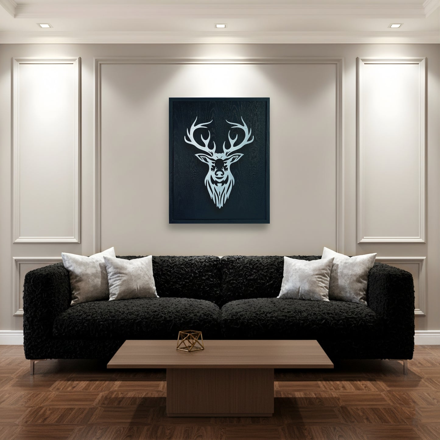 Modern living room with a black sofa, wooden coffee table, and deer head artwork in black wooden frame on the wall.