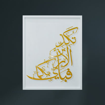 Gold Arabic calligraphy metal wall art mounted on a white wooden frame, shown against a dark charcoal background.