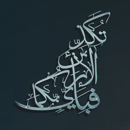 Arabic calligraphy artwork in a metallic silver tone, set against a dark navy background.