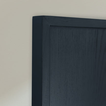 Close-up of a black wooden frame against a plain off-white wall.