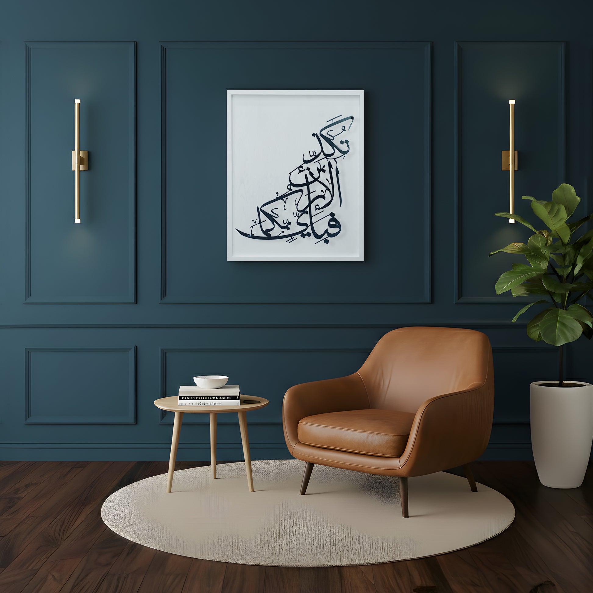 A framed Arabic calligraphy metal wall art on white wooden frame hangs on a dark teal paneled wall in a modern living room setting with a brown leather armchair, a small wooden side table, and a potted plant.