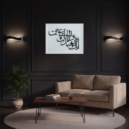 A framed black Arabic calligraphy metal wall art on a white wooden frame is displayed in a modern living room setting above a beige sofa, with black paneled walls and wall sconces in the background.