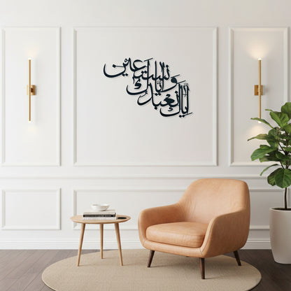 Black Arabic calligraphy metal wall art displayed on a white paneled wall in a modern living room setting with a tan leather armchair, a small wooden side table, and a potted plant.