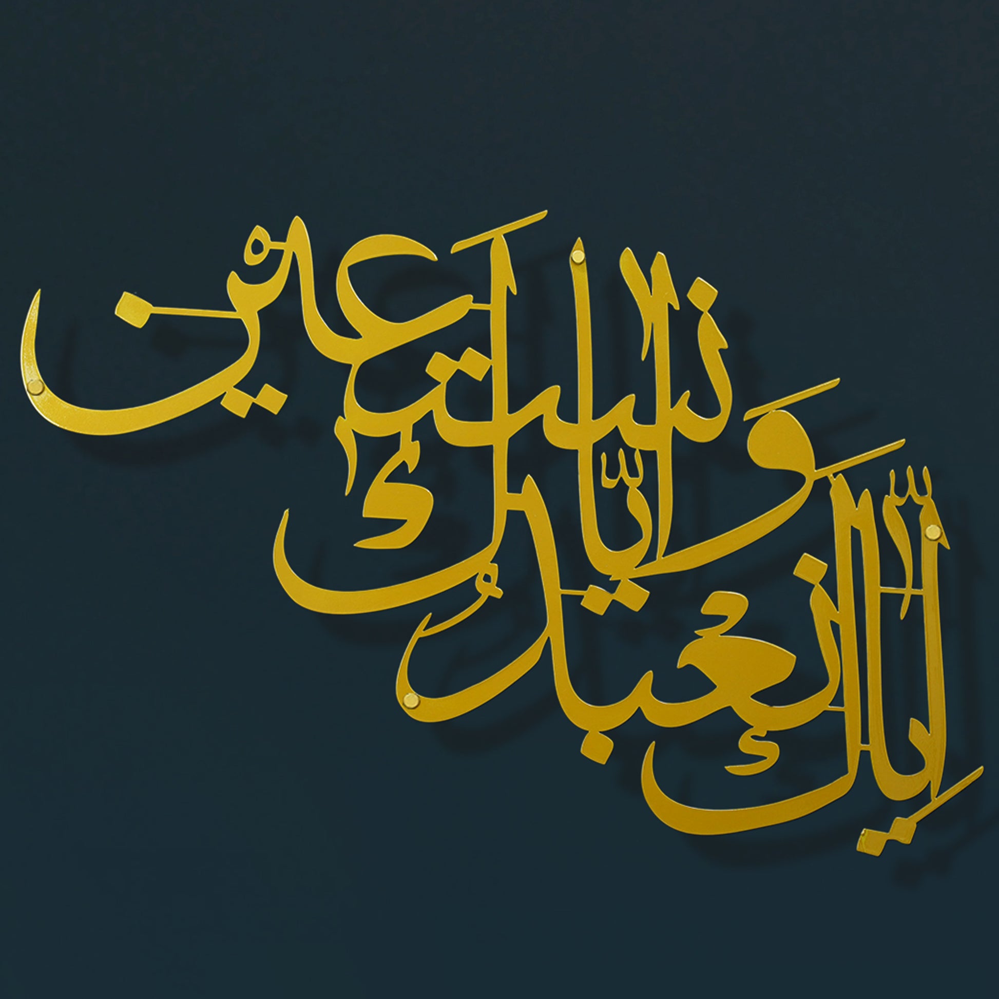 Gold Arabic calligraphy metal wall art stylized script against a dark navy background.