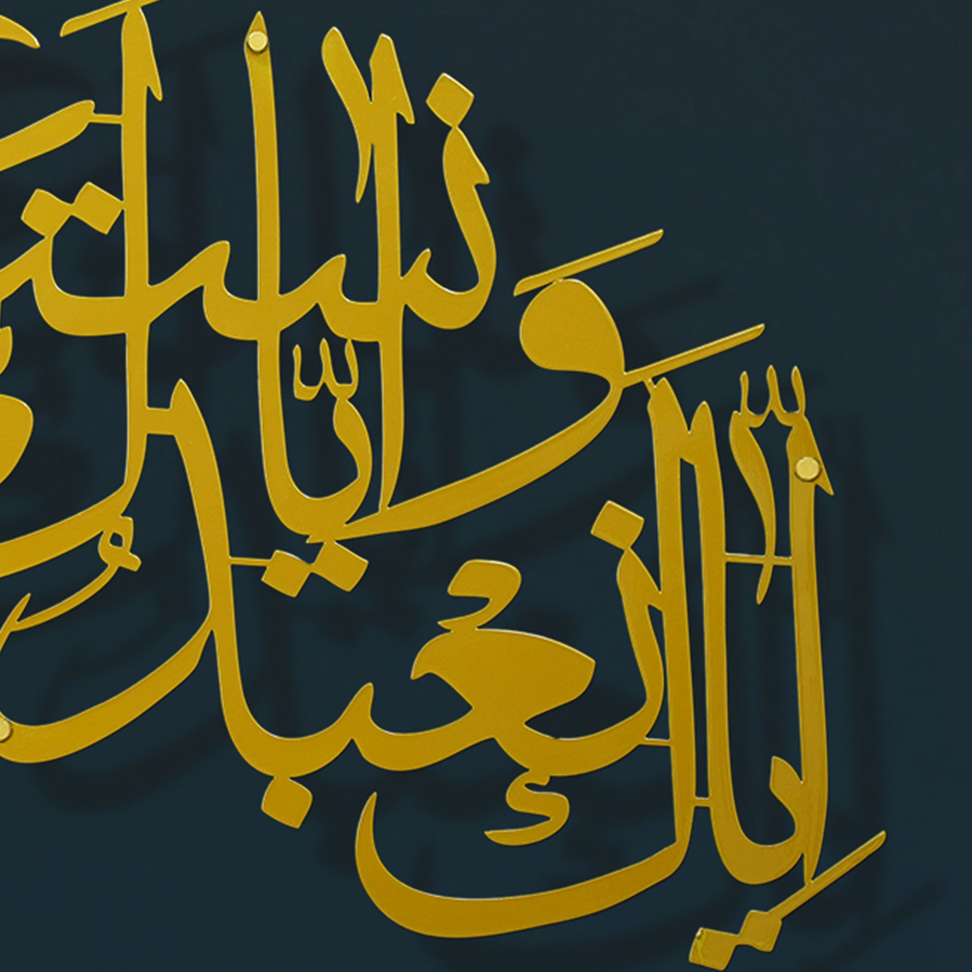 Gold Arabic calligraphy metal wall art mounted on a dark navy blue background.