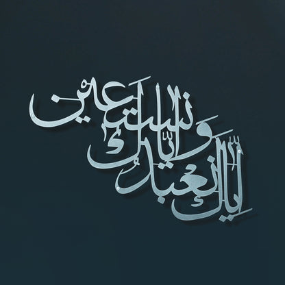 Arabic calligraphy metal wall art in a metallic silver tone on a dark teal background.