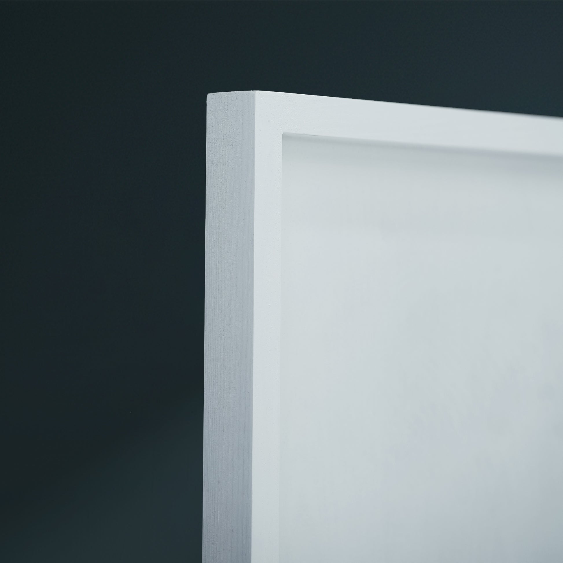 Close-up of a white frame corner against a dark charcoal background.