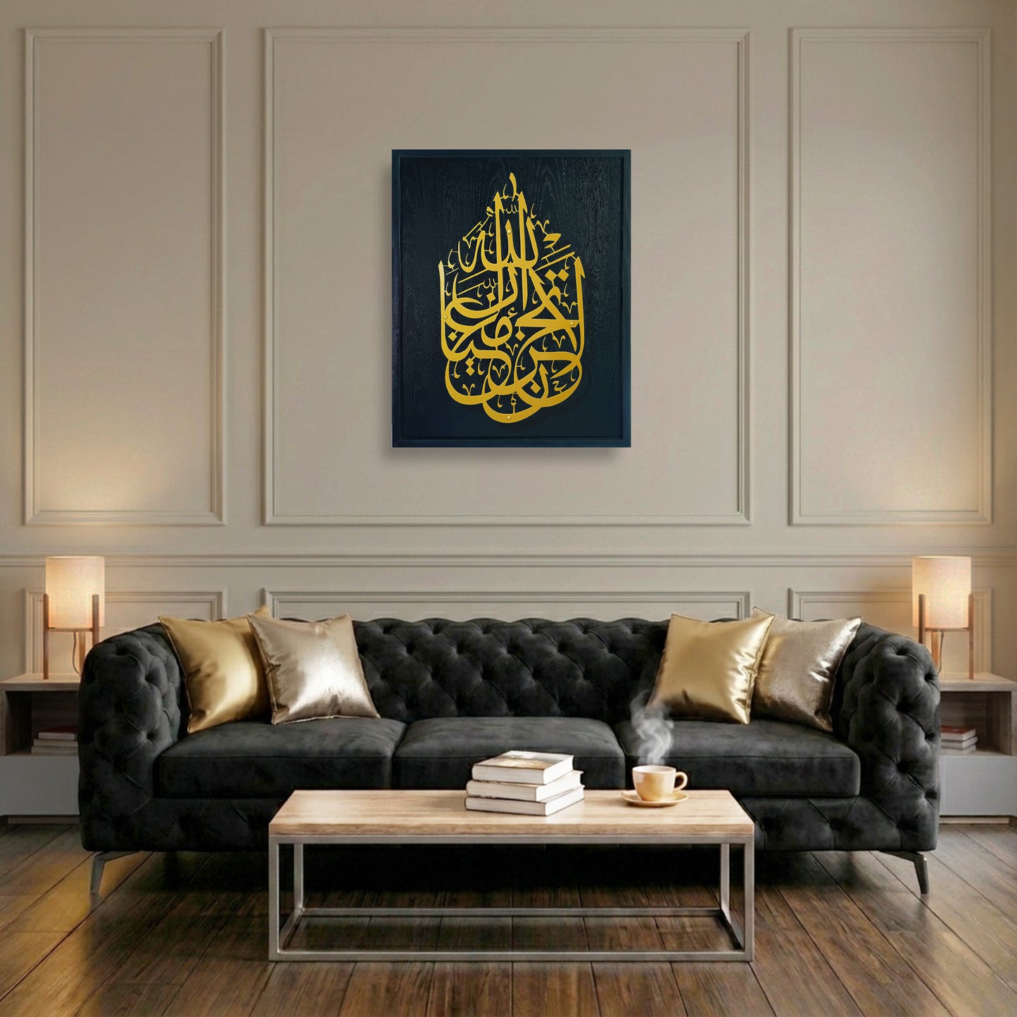 A framed wall art print featuring gold Arabic calligraphy on a black wooden frame, displayed above a black tufted sofa in a modern living room setting.