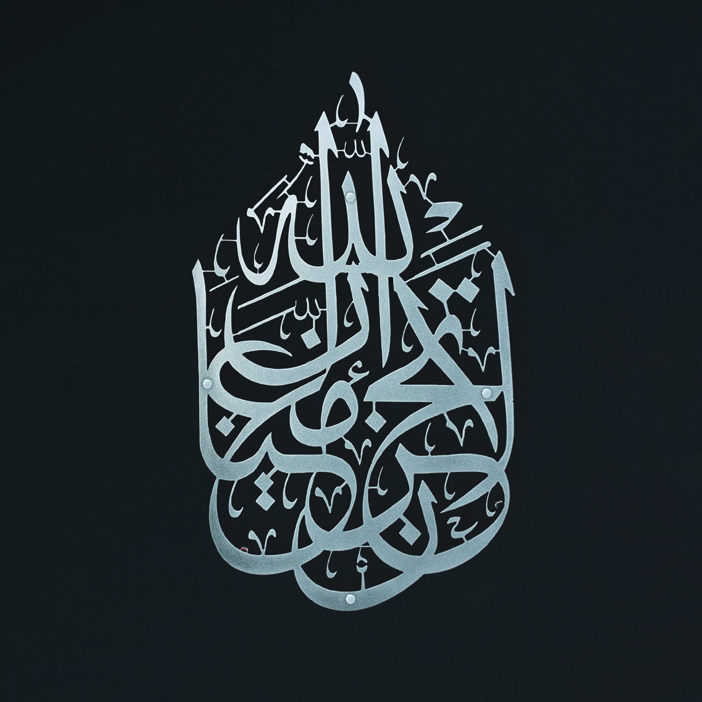 Silver La Tahzan İnnallahe Maana, Islamic  calligraphy Metal Wall Art forming a teardrop shape, centered on a solid black background.