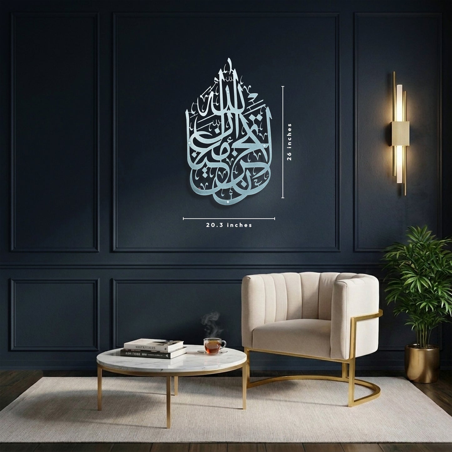 A styled interior room showing a large Silver La Tahzan İnnallahe Maana, Islamic  calligraphy Metal Wall Art piece mounted on a dark navy paneled wall. White dimension lines length 26 inches and width 20.3 inches.
